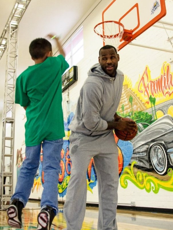 Photo of young boy playing basketball with Lebron James